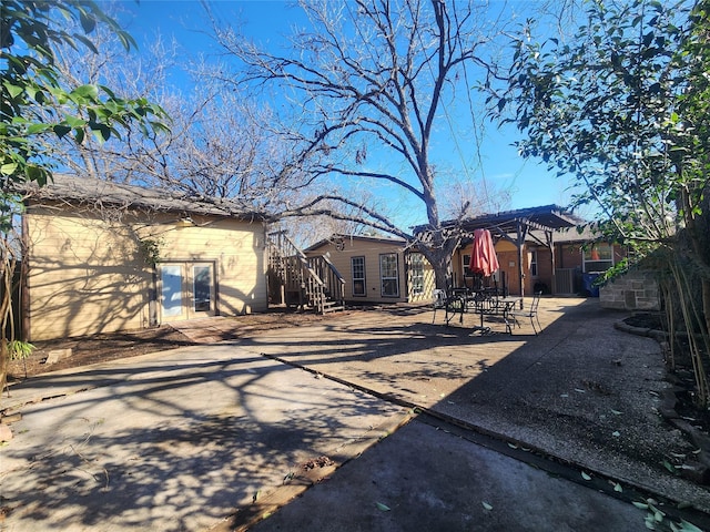 back of property with a pergola and a patio area