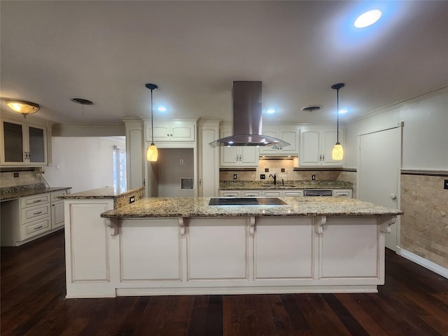 kitchen featuring light stone countertops, hanging light fixtures, island exhaust hood, a kitchen island, and sink