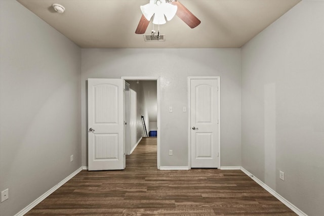 unfurnished bedroom featuring ceiling fan and dark wood-type flooring