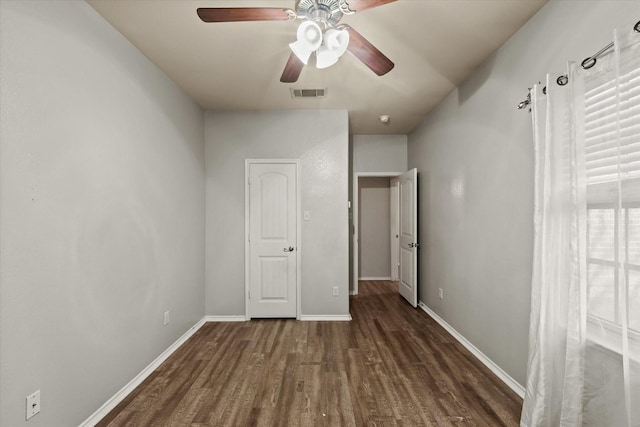 unfurnished bedroom with ceiling fan and dark hardwood / wood-style flooring