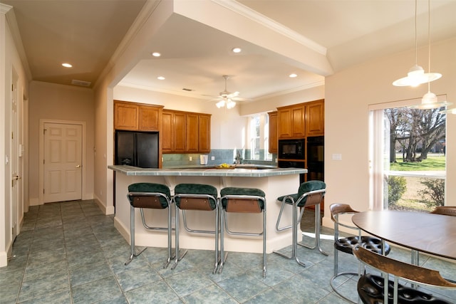 kitchen featuring black appliances, hanging light fixtures, ceiling fan, decorative backsplash, and kitchen peninsula