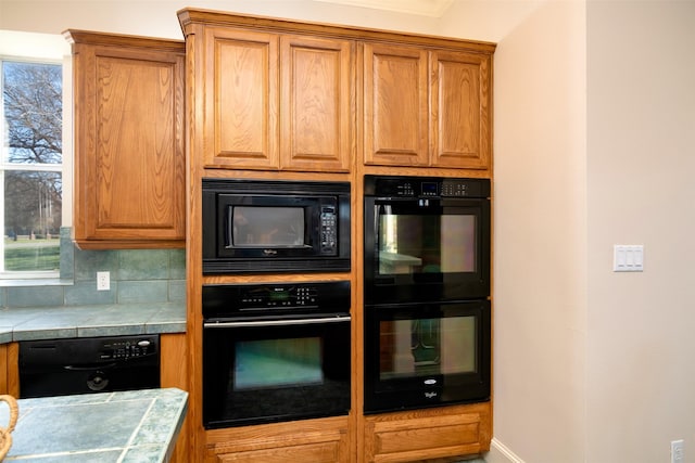 kitchen with black appliances, tasteful backsplash, and tile countertops