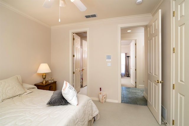 carpeted bedroom featuring ceiling fan and crown molding