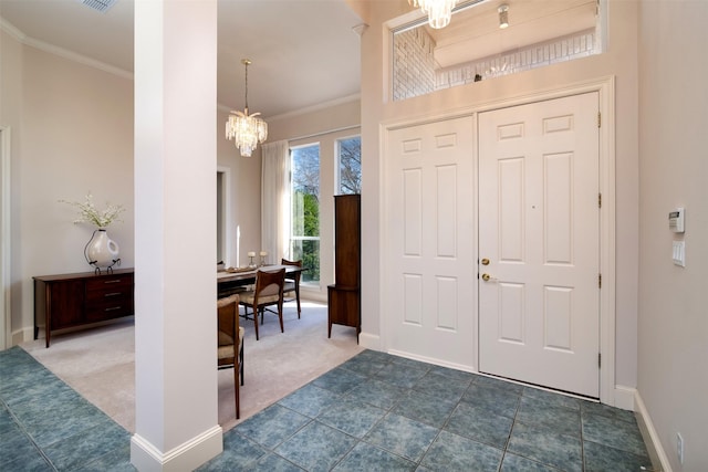 foyer entrance with crown molding, a chandelier, and dark colored carpet