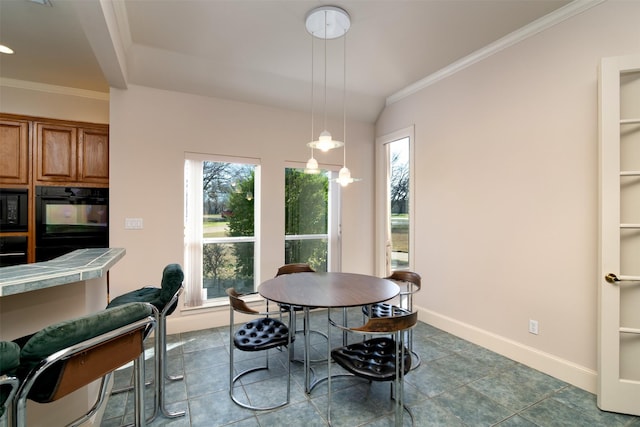 tiled dining area with lofted ceiling and crown molding