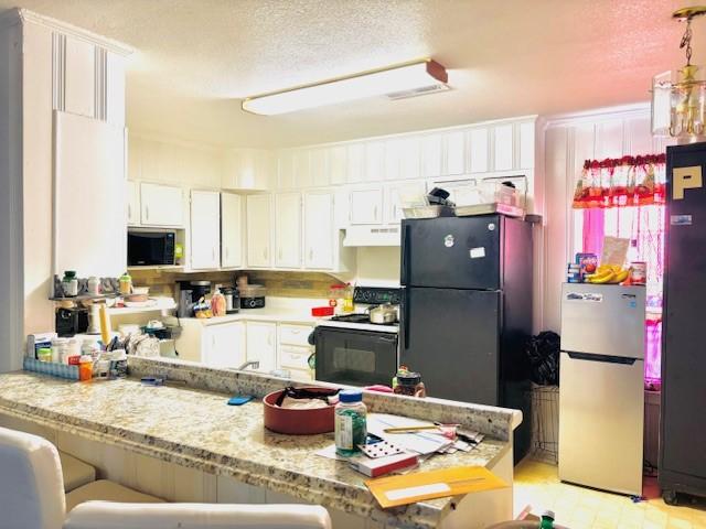 kitchen featuring black appliances, white cabinetry, kitchen peninsula, and a textured ceiling