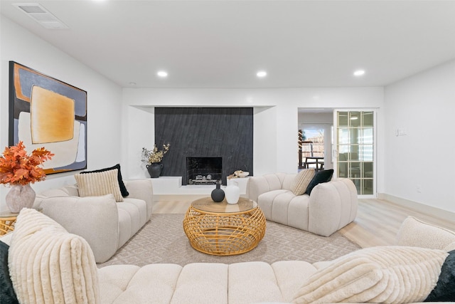 living area featuring visible vents, recessed lighting, wood finished floors, and a fireplace