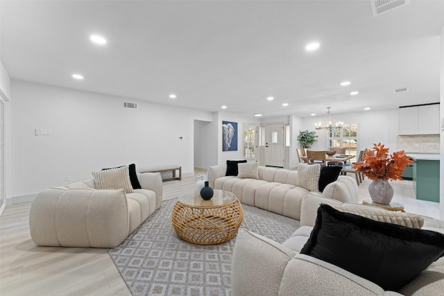 living area with an inviting chandelier, light wood-type flooring, recessed lighting, and visible vents