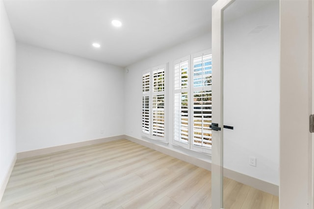 unfurnished room with baseboards, recessed lighting, and wood finished floors