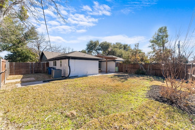 exterior space with central AC unit, a fenced backyard, and a garage