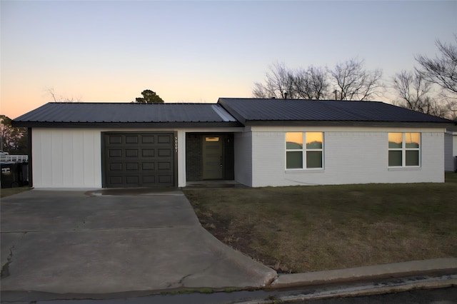 ranch-style home with a yard and a garage