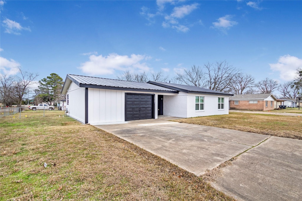 single story home featuring a lawn and a garage