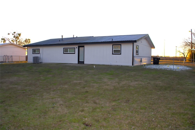 rear view of house with a yard and central AC