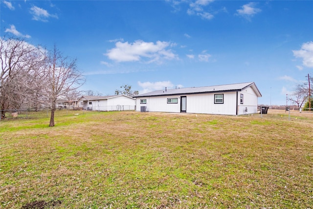 back of house featuring central AC unit and a yard