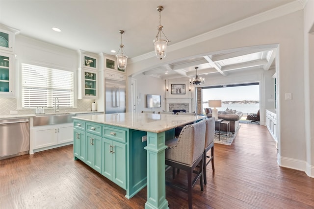 kitchen with white cabinets, a fireplace, coffered ceiling, dishwasher, and a kitchen island