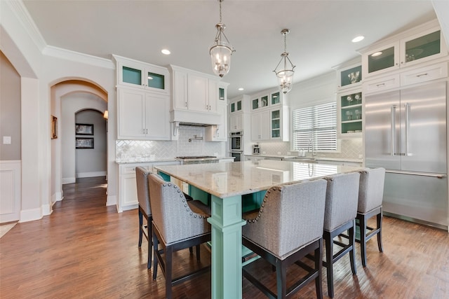 kitchen featuring a kitchen bar, white cabinetry, a kitchen island, and appliances with stainless steel finishes