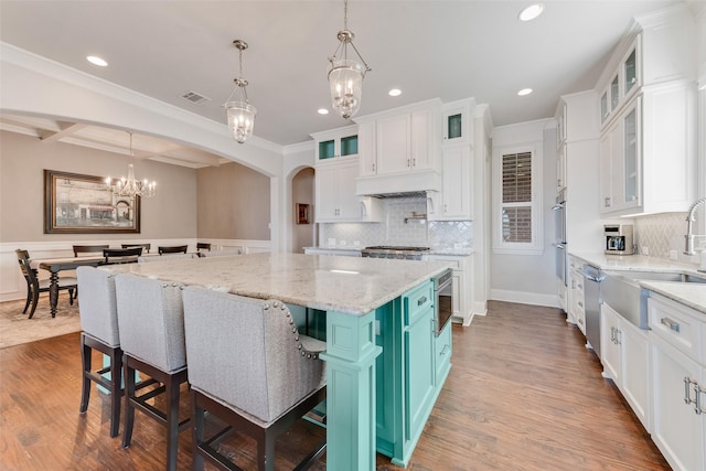 kitchen with beamed ceiling, a kitchen breakfast bar, a spacious island, and white cabinetry