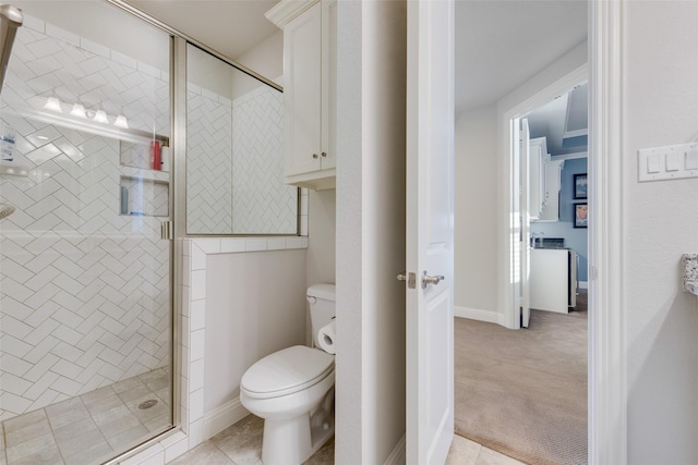 bathroom with tile patterned flooring, a shower with shower door, and toilet