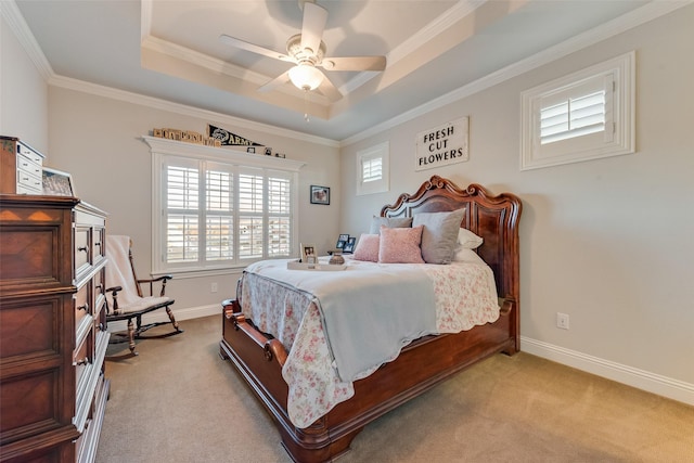 bedroom with ceiling fan, crown molding, light carpet, and a tray ceiling