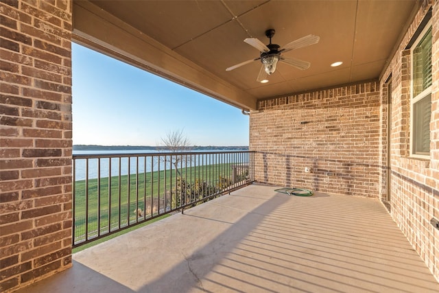 balcony featuring ceiling fan and a water view