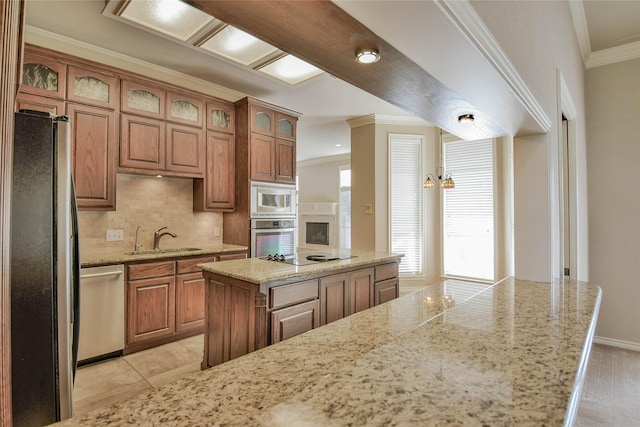 kitchen featuring light stone countertops, appliances with stainless steel finishes, tasteful backsplash, sink, and a center island