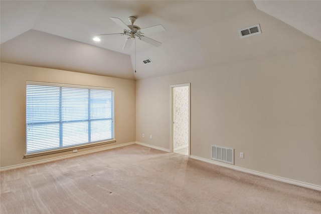 empty room with ceiling fan, light colored carpet, and vaulted ceiling