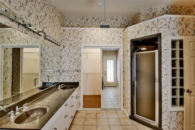 bathroom with tile patterned floors, vanity, and walk in shower