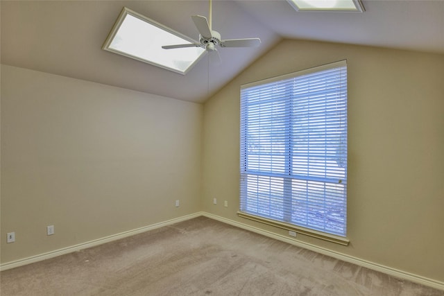 spare room featuring ceiling fan, light carpet, and vaulted ceiling