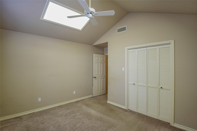 unfurnished bedroom with ceiling fan, vaulted ceiling, light carpet, and a closet