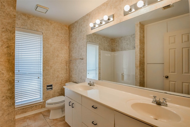 bathroom with tile patterned flooring, a shower, vanity, and toilet