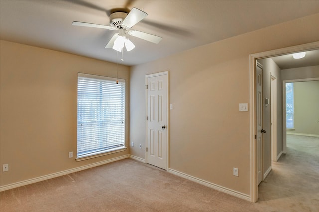 carpeted spare room featuring ceiling fan