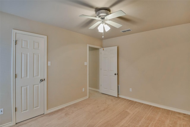 carpeted spare room with ceiling fan