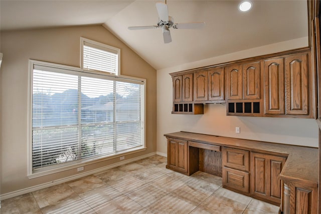 tiled home office featuring built in desk, plenty of natural light, ceiling fan, and vaulted ceiling