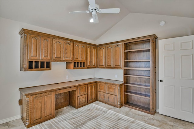 office space with ceiling fan, light tile patterned floors, built in desk, and vaulted ceiling