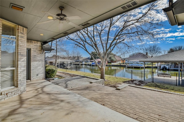 view of patio with ceiling fan and a water view