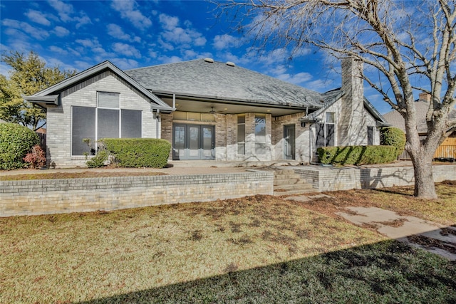 view of front facade with ceiling fan and a front lawn