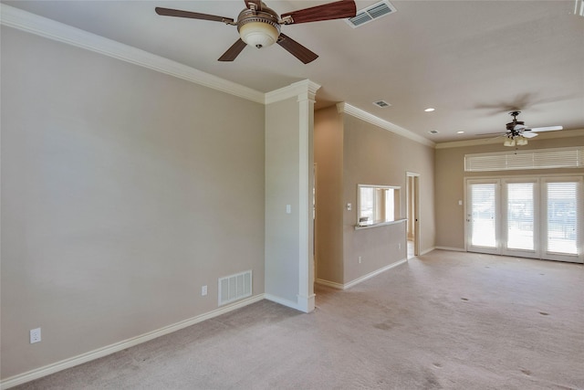 spare room with light carpet, ornate columns, ceiling fan, and crown molding