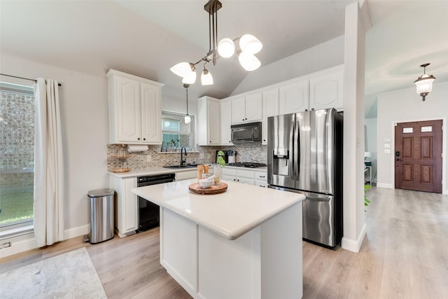 kitchen featuring black appliances, pendant lighting, a center island, white cabinetry, and lofted ceiling