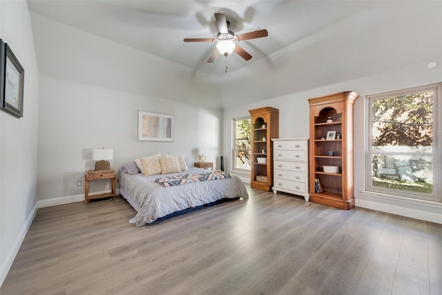 bedroom with ceiling fan, light wood-type flooring, and multiple windows