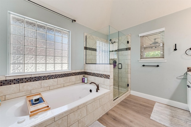 bathroom with hardwood / wood-style flooring, vanity, separate shower and tub, and a wealth of natural light