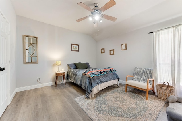 bedroom with light hardwood / wood-style floors, ceiling fan, and lofted ceiling