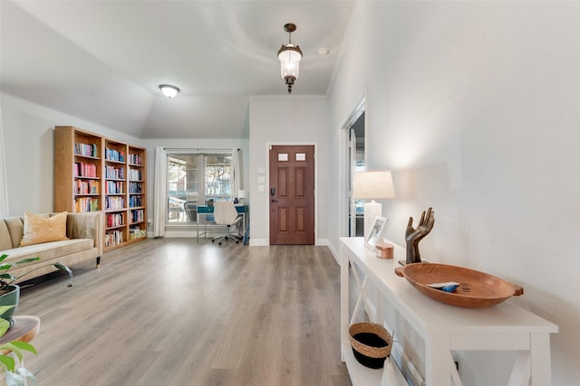 entrance foyer with light hardwood / wood-style floors and vaulted ceiling