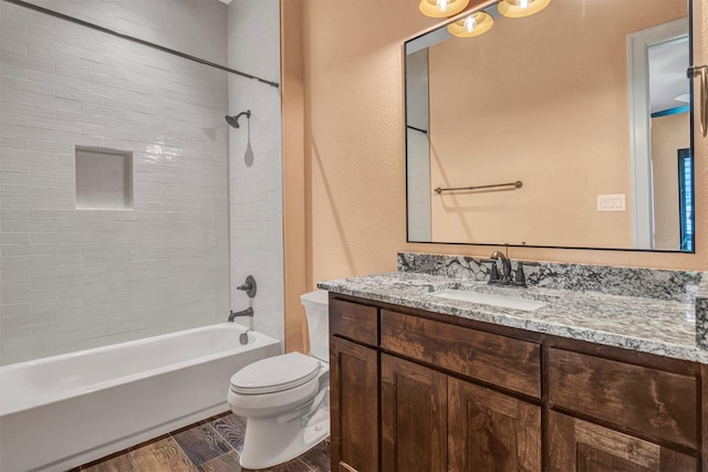 full bathroom with toilet, vanity, and tiled shower / bath