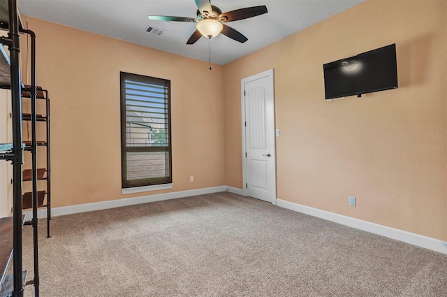 carpeted spare room with ceiling fan