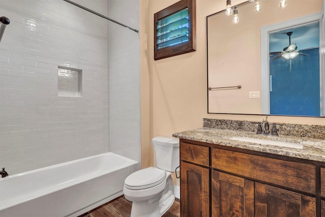 full bathroom featuring ceiling fan, tiled shower / bath combo, toilet, vanity, and hardwood / wood-style flooring