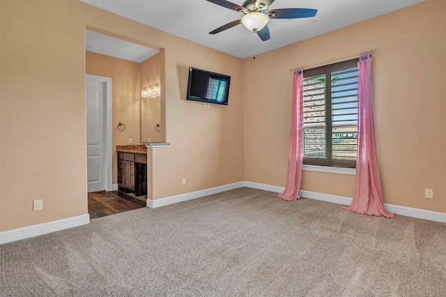 carpeted spare room featuring ceiling fan