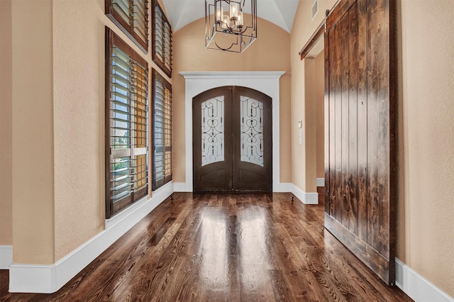 entrance foyer with a chandelier, french doors, dark hardwood / wood-style floors, and vaulted ceiling