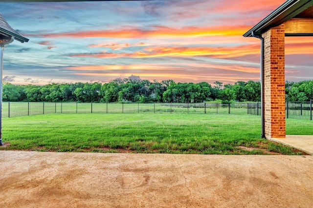 yard at dusk featuring a patio area