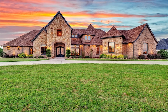 view of front of home with a lawn and french doors