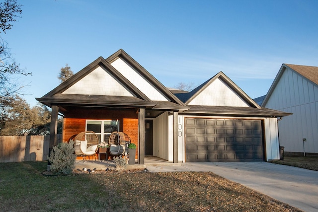 view of front of house with a front yard, a porch, and a garage